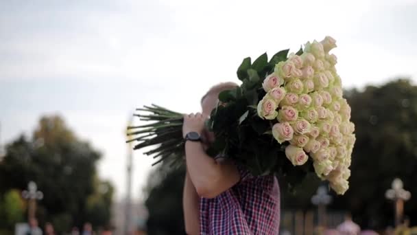 Άνθρωπος Ένα Μεγάλο Μπουκέτο Τριαντάφυλλα Στον Ώμο Του Στέκεται Την — Αρχείο Βίντεο