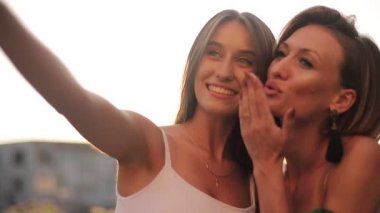İki güzel kız arkadaş selfie çekiyor.