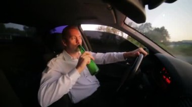 Genç adam arabada bira içiyor. Direksiyondaki sarhoş sürücü. Alkollü araç kullanma ve başarısız iş konsepti