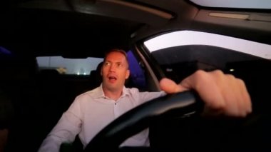 Direksiyondaki sarhoş sürücü. Genç adam arabada bira içiyor.. 