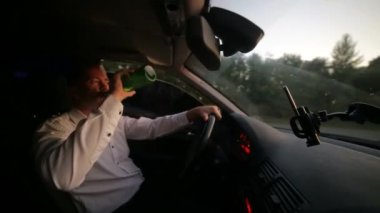 Araba kullanırken bira içen erkek sürücü