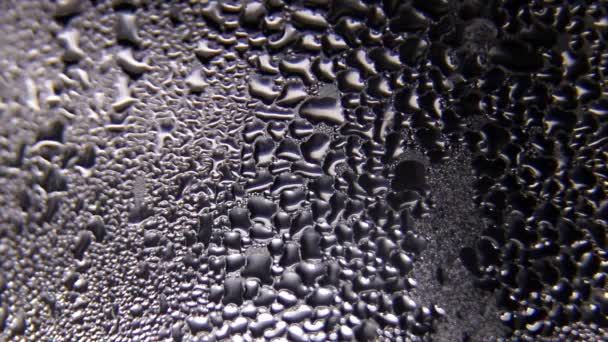Капли дождя на стекле с черным фоном . — стоковое видео
