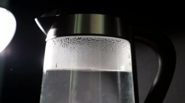 Şeffaf duvarları olan elektrikli su ısıtıcısı. Parlak kaynamış cam çaydanlık.