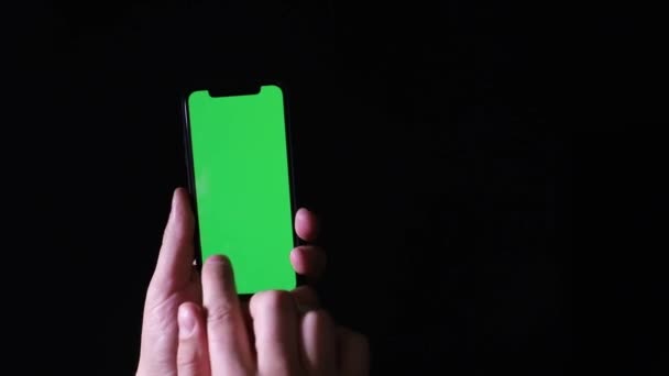 黒の背景に緑の画面のクロマキーを持つスマートフォン — ストック動画
