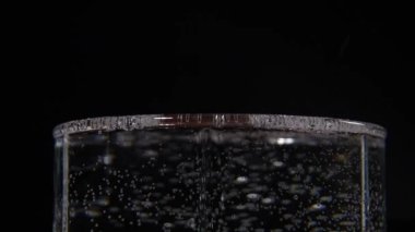 Siyah arka planda karbonatlı suyun yakın plan görüntüsü.