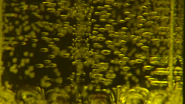Κίτρινο ανθρακούχο νερό σε ποτήρι σε μαύρο φόντο — Αρχείο Βίντεο