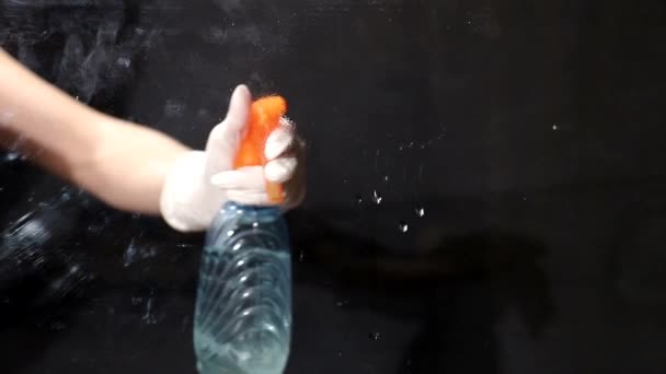 Mujer con guantes rociando limpiadores usando detergente y paño de limpieza de ventanas — Vídeos de Stock