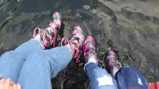 Mutter und Tochter sitzen auf der Seebrücke und genießen einen Sommertag. — Stockvideo