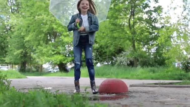 Criança feliz pula em uma poça — Vídeo de Stock