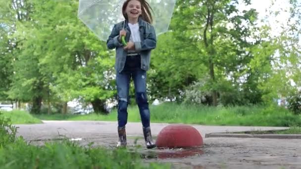 Happy child jumps into a puddle — Stock Video