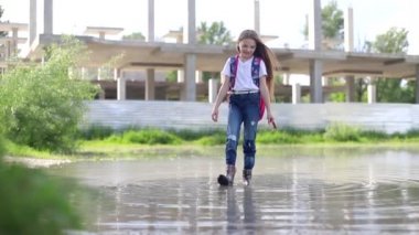 Su birikintisinde oynayan küçük kız