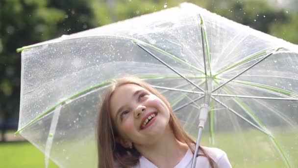 Счастливый ребенок под дождем с зонтиком — стоковое видео