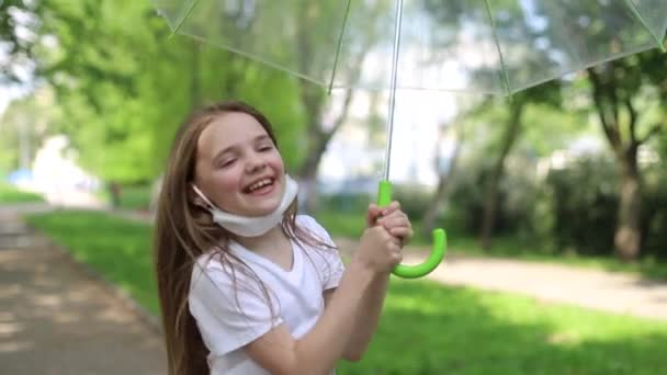 Criança feliz desfruta da chuva de verão em um parque da cidade — Vídeo de Stock