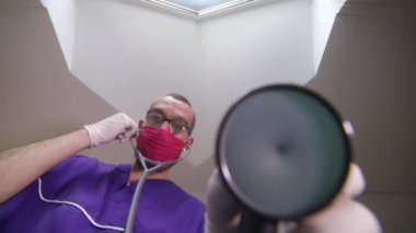 Doktor eldiven takar ve hastanın muayenesine hazırlanır.
