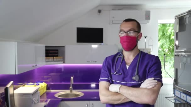 Hezký veterinární lékař s červenou maskou na obličeji, pet klinika — Stock video