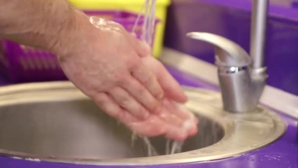 El doctor se lava las manos. Hermoso fondo púrpura. Lugar para texto publicitario — Vídeos de Stock