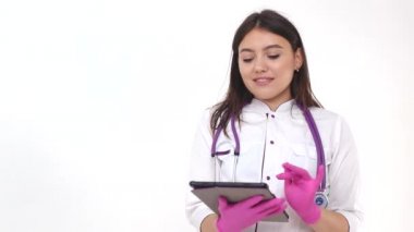 Elinde tabletle güzel bir doktor kız. Modern tıpta başarılı genç bir doktor internet ağını kullanır