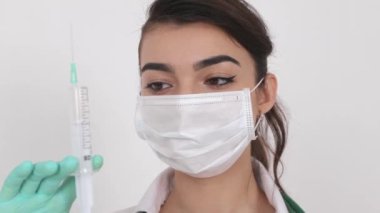 Coronavirus aşısı olan tıbbi maskeli bir kız doktor (COVID-19).