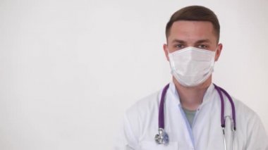 Tıbbi maske takan bir doktor işaret edip, bir tarafı işaret eder. Modern tıpta başarılı genç bir doktor.