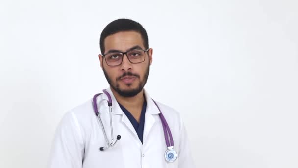 El doctor es egipcio. Médico joven con gafas sobre fondo blanco . — Vídeos de Stock