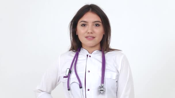 Hübsche brünette Ärztin schaut in die Kamera und lächelt. Medizin und Gesundheit — Stockvideo