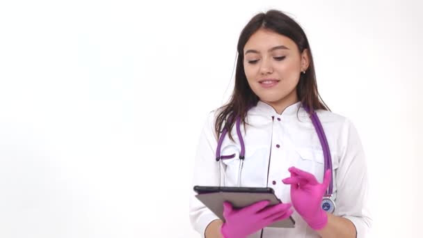 손에 알약을 들고 있는 아름다운 의사. 현대 의학에서 성공을 거둔 한 젊은 의사가 인터넷 네트워크를 사용하다 — 비디오