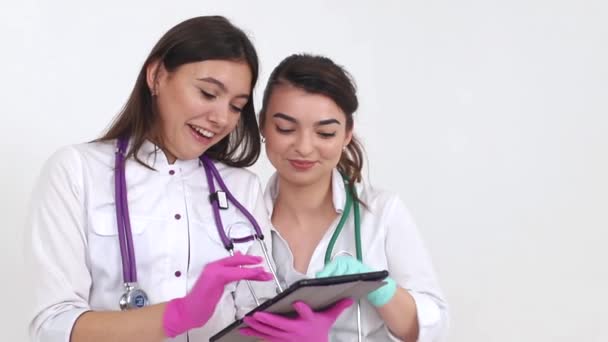 Dos estudiantes se ríen alegremente mirando la tableta, chicas felices en las redes sociales . — Vídeos de Stock