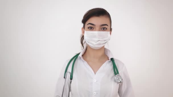 Seorang dokter perempuan bertopeng medis yang memegang jarum suntik dengan vaksinasi terhadap coronavirus (COVID-19). — Stok Video