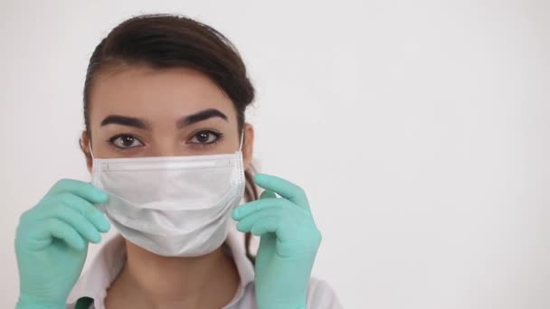 若い医師は、コロナウイルスのパンデミック(COVID-19の普及を防ぐ医療用マスクを着用してください)). — ストック動画