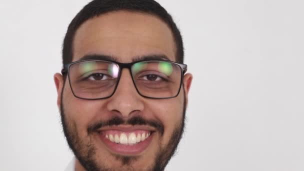 Ein fröhlicher arabischer Arzt im Laborkittel setzt sich eine Brille auf — Stockvideo