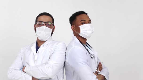 Beyaz arka planda maskeli genç Afrikalı Amerikalı doktorlar.. — Stok video