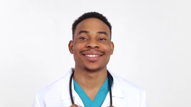 Um jovem médico afro-americano olha para a câmara. Estudante universitário de medicina — Vídeo de Stock