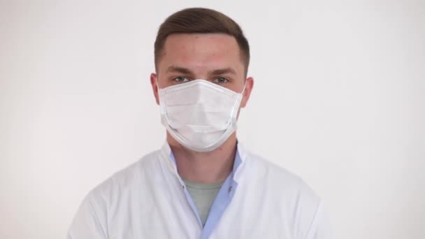 若い医者は医療マスクを外します。パンデミックの終わり(COVID-19)). — ストック動画