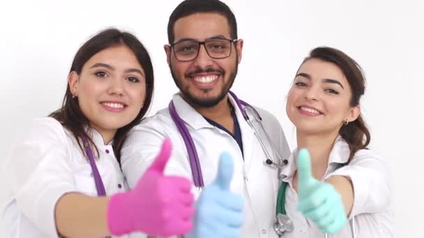 Τρεις νεαροί, χαμογελαστοί γιατροί κοιτάζουν την κάμερα και δείχνουν ψηλά τους αντίχειρες.. — Αρχείο Βίντεο