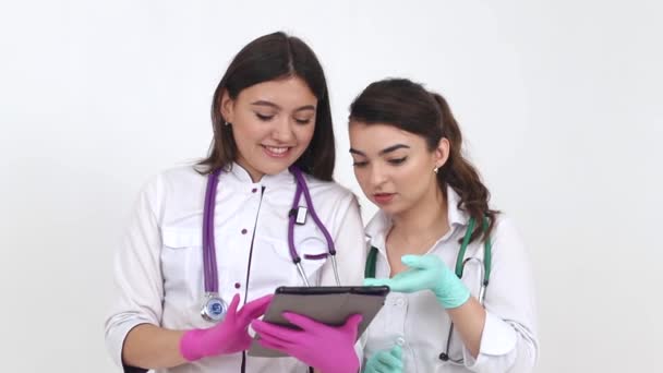 Two girls doctors use a digital tablet computer for training. — Stock Video