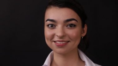 Siyah arka planda esmer bir kızın yüzü.