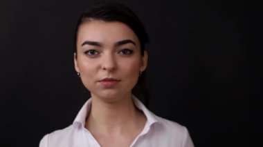 Siyah arka planda esmer bir kızın yüzü.