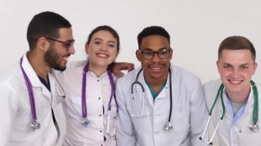 Hastanede gülümseyen bir grup tıp öğrencisi, karışık ırktan doktorlar.