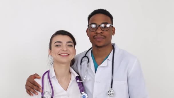 Unge glade læger stående i omfavnelse og smilende isoleret på hvid baggrund – Stock-video