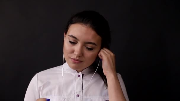 Brunette girl listens to music in headphones — Stock Video