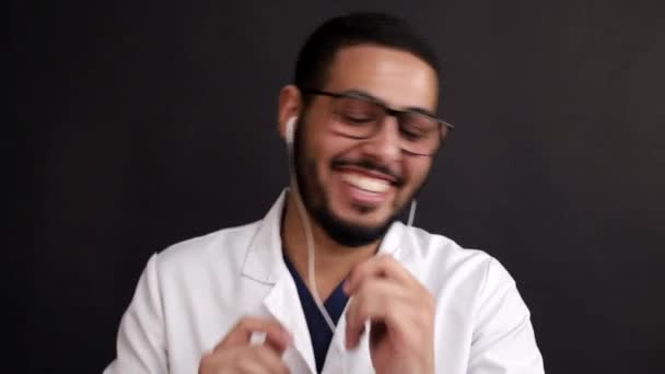 L'uomo africano felice e sorridente ascolta felicemente musica tramite smartphone e balli — Video Stock