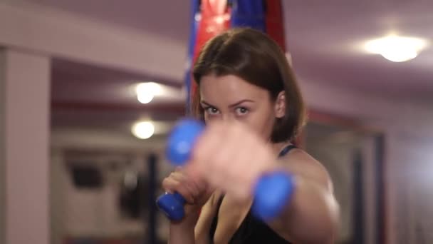Smuk pige bokser med håndvægte i hendes hænder. Stærk kvinde. Amatør boksning – Stock-video
