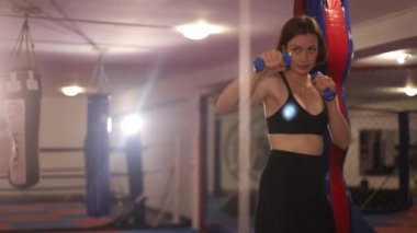 Elinde dambıllar olan güzel bir kız boksör. Güçlü bir kadın. Amatör boks.