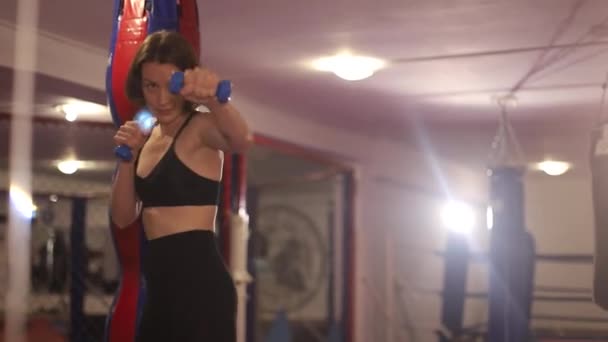 Mujer atlética practicando golpes mientras entrena en el gimnasio. Arte marcial femenino — Vídeos de Stock