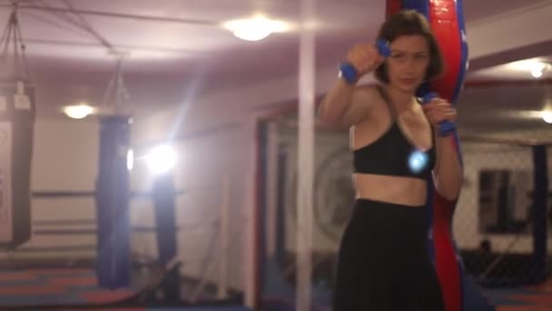 운동 선수인 여자가 헬스클럽에서 훈련하면서 펀치를 부는 모습. — 비디오