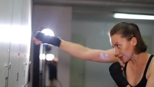 Mujer atlética practicando golpes mientras entrena en el gimnasio. — Vídeos de Stock