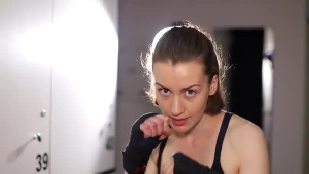 Девушка-боксер закручивает бинты перед боем. Женский бокс — стоковое видео