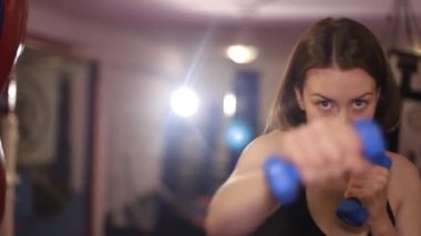Güçlü kız boksör spor salonunda antrenman yapıyor. Saldırgan kadın..