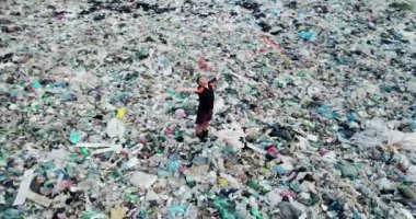 Ekolojik felaket, kıyamet ya da mahşer konsepti. Çöpün ortasında bir adam duruyor.