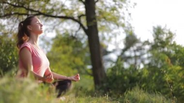 Kız güneşli bir günde yoga yapıyor.